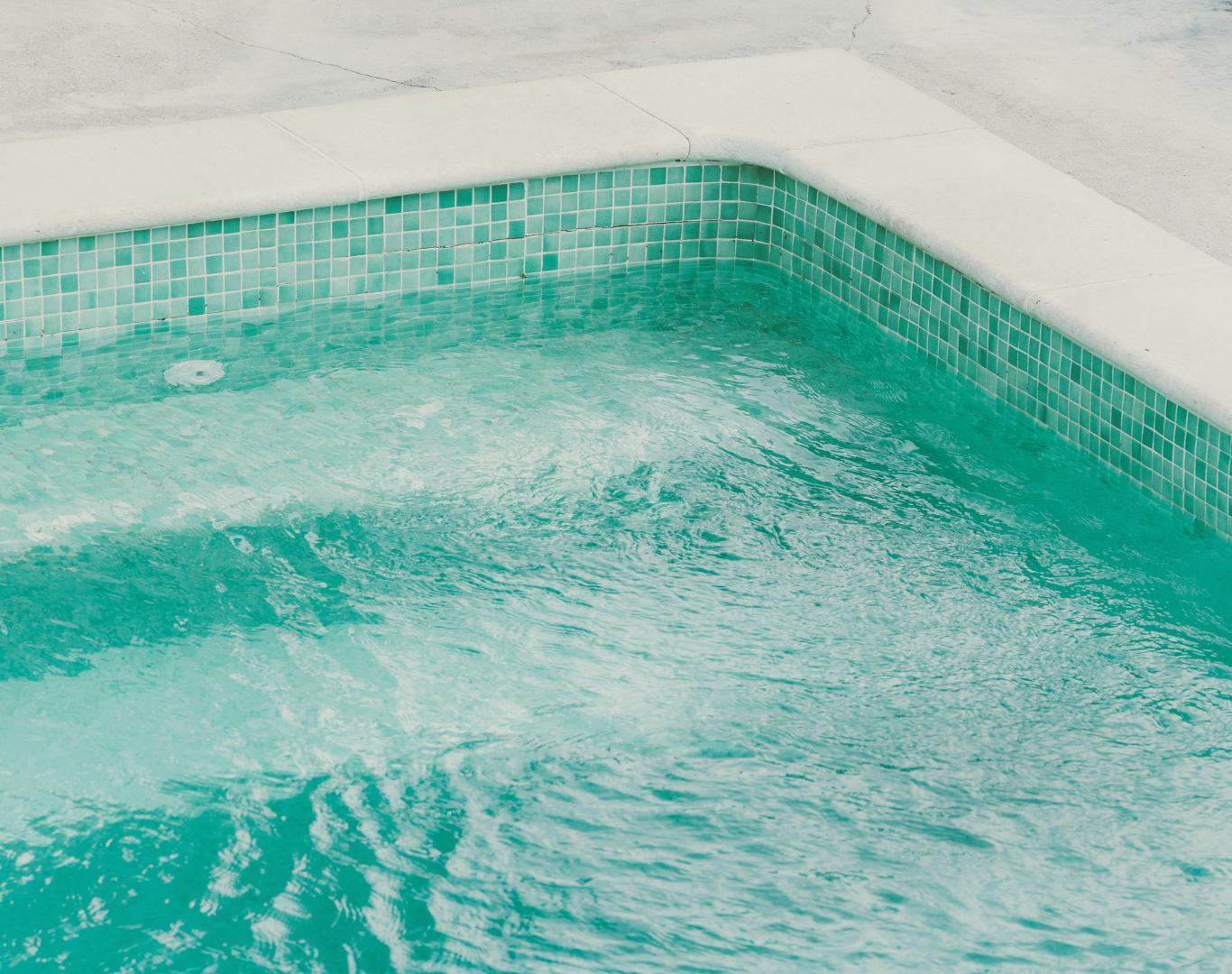 Professional technician performing routine Pool Service in Hunting Valley, OH for residential backyard swimming pool maintenance
