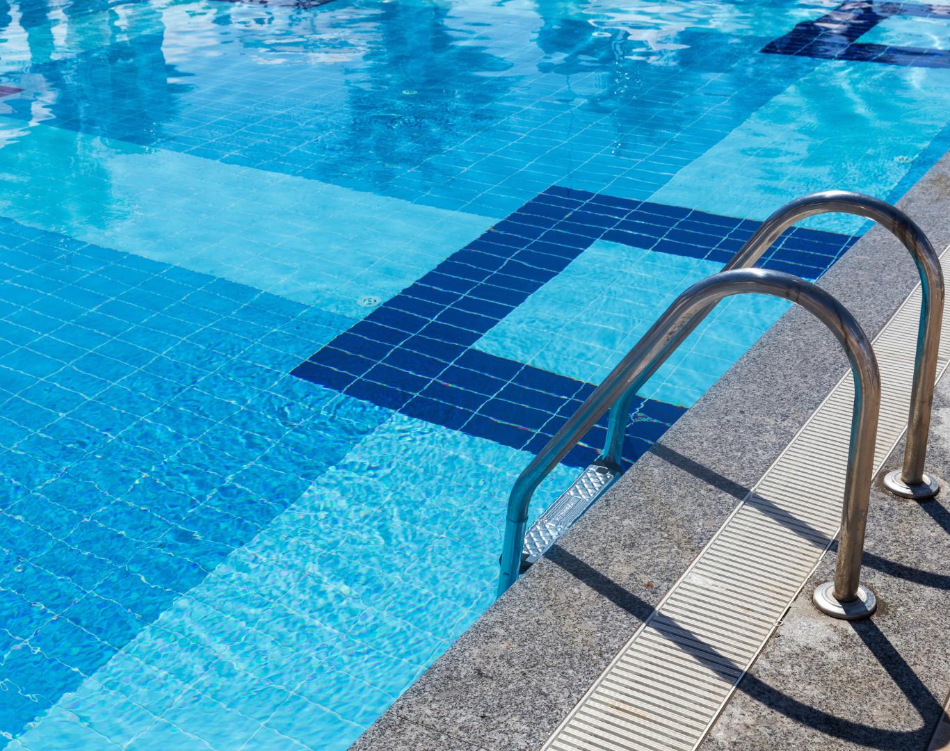 Professional technician performing routine Pool Service in Seven Hills, OH for residential backyard swimming pool maintenance